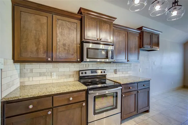 a kitchen with stainless steel appliances granite countertop a sink stove and microwave
