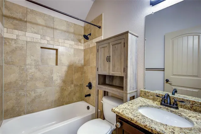 a bathroom with a granite countertop sink toilet and shower