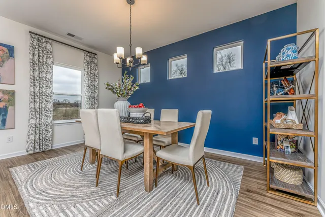 a view of a dining room with furniture wooden floor and chandelier