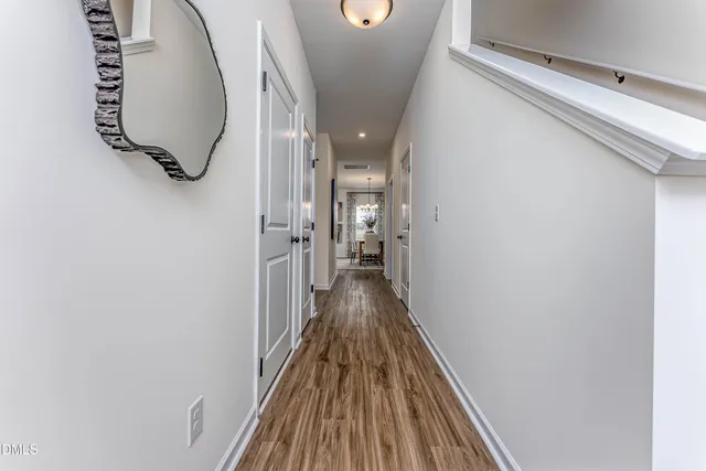 a view of a hallway with wooden floor and staircase