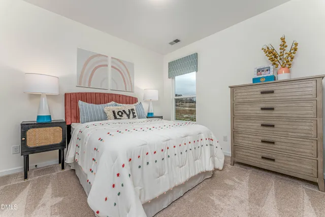 a bedroom with a bed a lamp and a chandelier