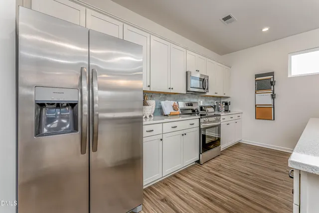 a kitchen with a refrigerator and a stove top oven