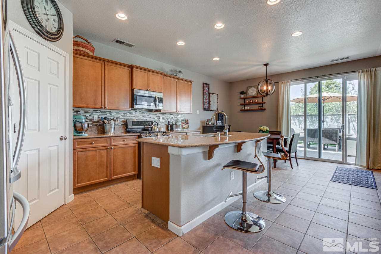 9275 Hummer Drive Reno, NV 89521 - Photo 11 of 33 a kitchen with stainless steel appliances granite countertop a refrigerator a sink a stove a dining table and chairs