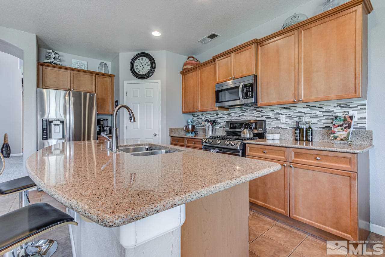 9275 Hummer Drive Reno, NV 89521 - Photo 14 of 33 a kitchen with stainless steel appliances granite countertop a sink a microwave cabinets and a refrigerator