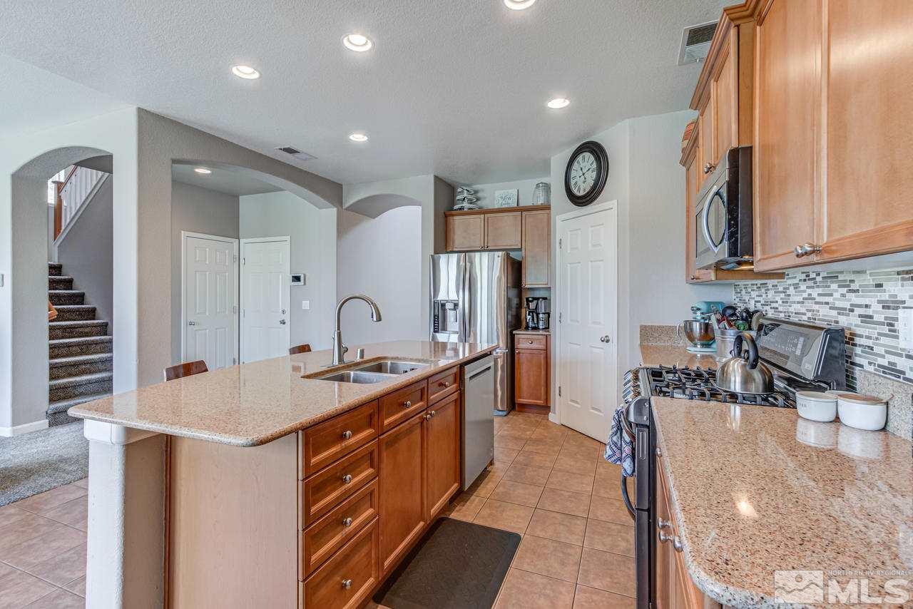 9275 Hummer Drive Reno, NV 89521 - Photo 15 of 33 a kitchen with stainless steel appliances granite countertop a sink stove and cabinets