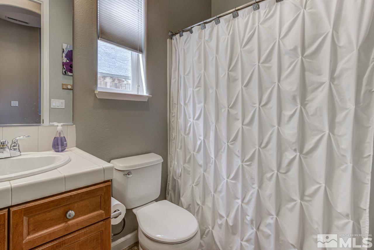 9275 Hummer Drive Reno, NV 89521 - Photo 18 of 33 a bathroom with a granite countertop toilet sink and mirror
