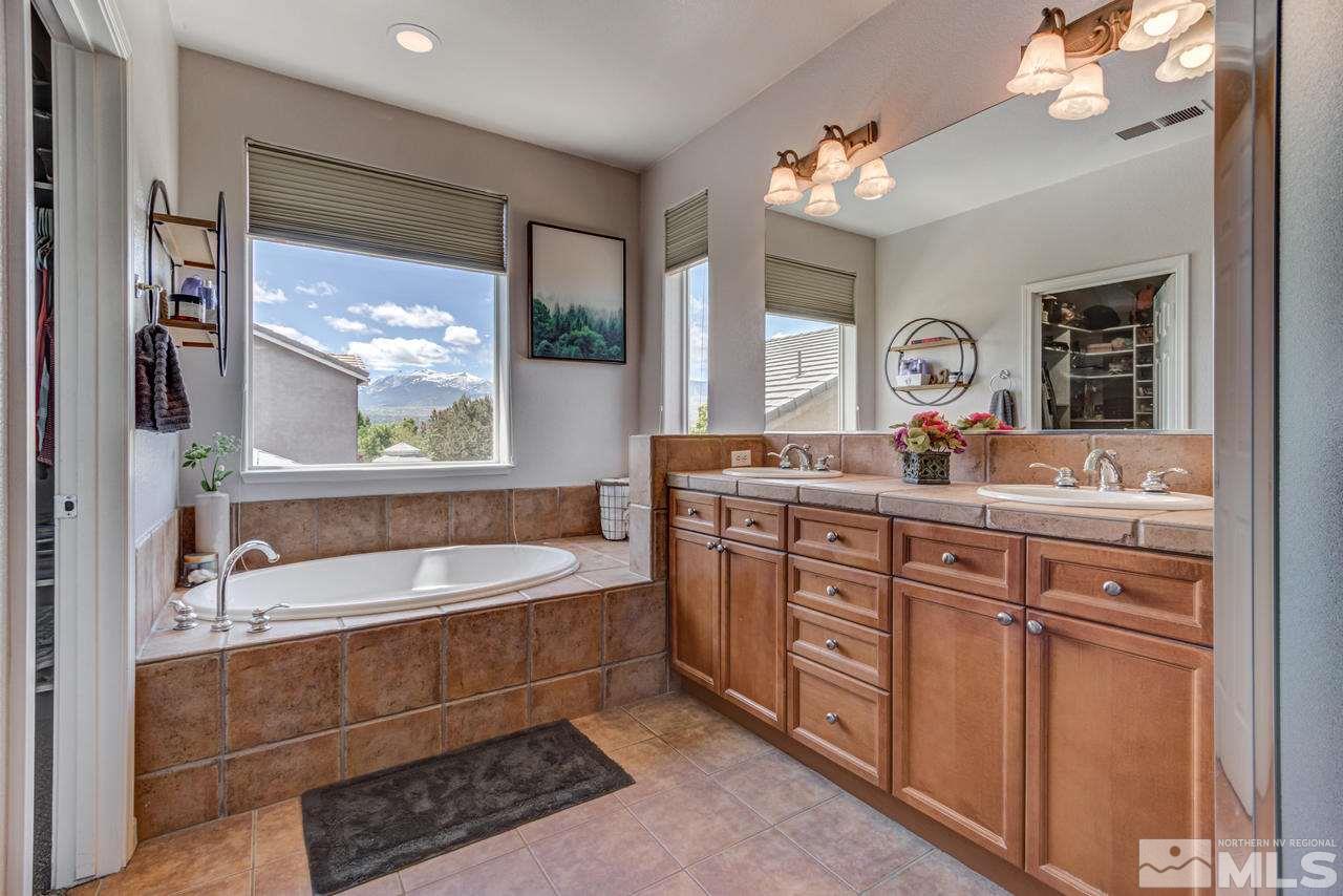 9275 Hummer Drive Reno, NV 89521 - Photo 25 of 33 a spacious bathroom with a double vanity sink a mirror a bathtub and window