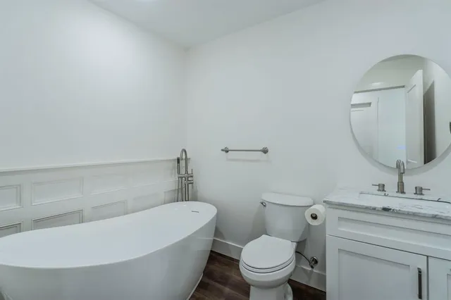 a bathroom with a toilet a sink a mirror and bathtub