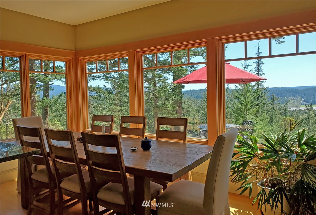 400 Cormorant Bay Road Orcas Island, WA 98245 - Photo 18 of 39 a view of a dining room with furniture large windows and wooden floor