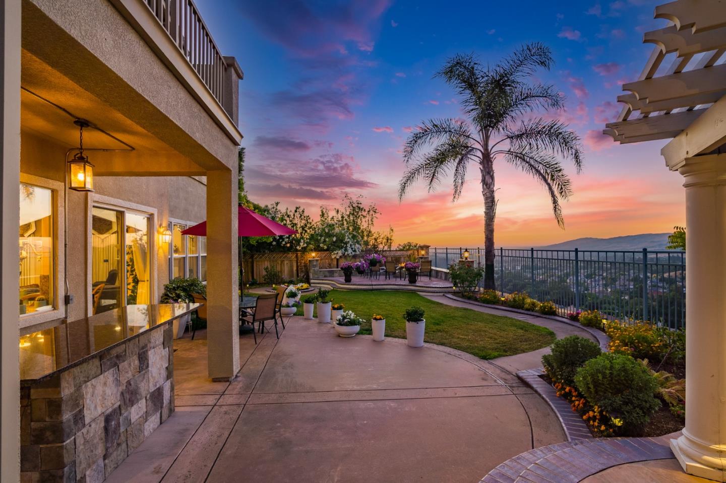 5793 Cannes Place San Jose, CA 95138 - Photo 9 of 29 a view of a patio with a table and chairs under an umbrella with palm trees