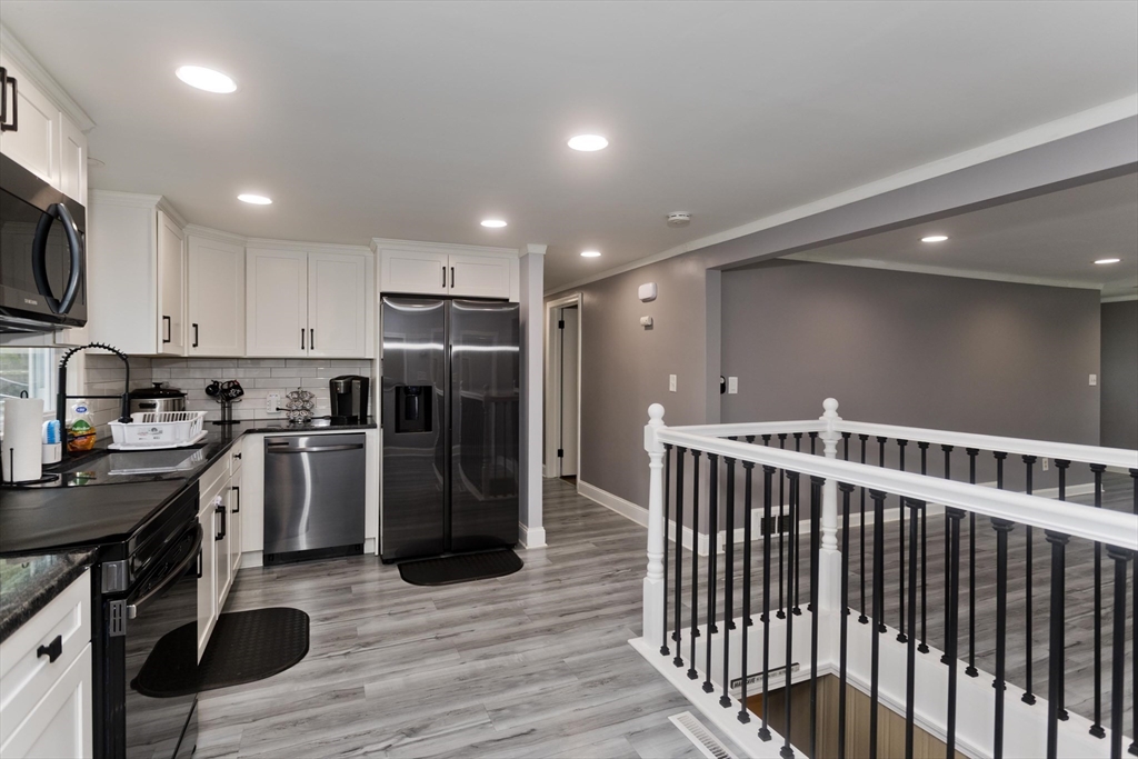 83 Chalmers Street Springfield, MA 01118 - Photo 4 of 40 a kitchen with stainless steel appliances granite countertop a refrigerator a stove top oven a sink and dishwasher