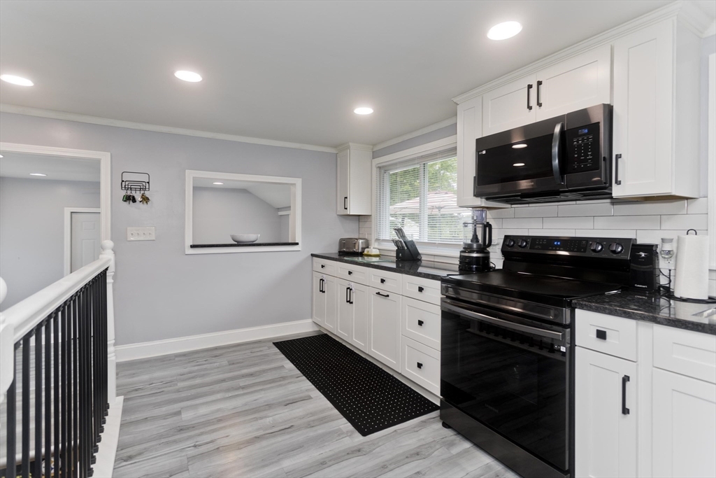 83 Chalmers Street Springfield, MA 01118 - Photo 5 of 40 a kitchen with stainless steel appliances kitchen island granite countertop a stove a sink and a microwave
