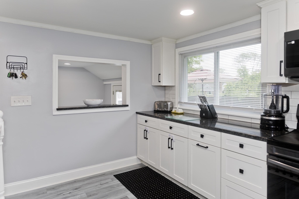 83 Chalmers Street Springfield, MA 01118 - Photo 6 of 40 a kitchen with granite countertop white cabinets and black stainless steel appliances