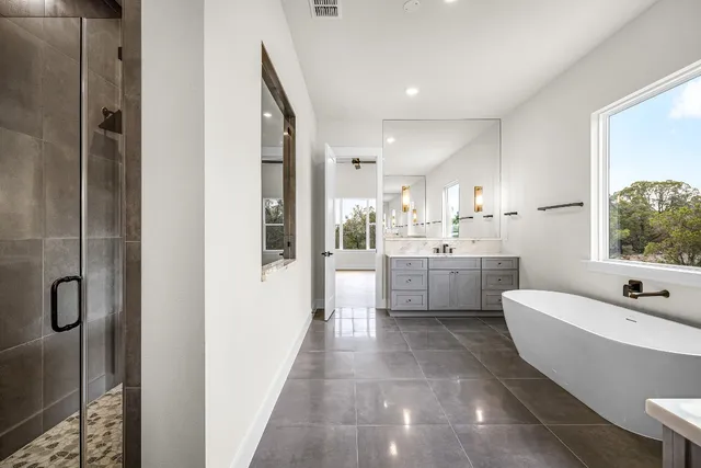 a bathroom with a granite countertop sink mirror bathtub and toilet