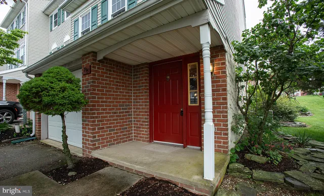 a view of a hallway to an empty room with wooden floor and a cabinet
