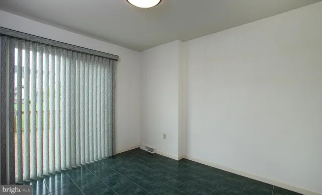 an empty room with a window and a ceiling fan