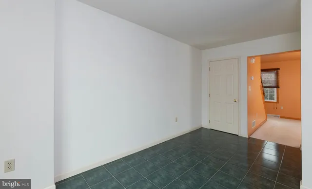 an empty room with a chandelier fan