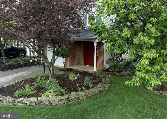 a front view of a house with a garden and plants