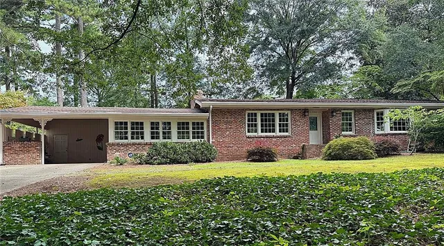a front view of a house with a yard and trees
