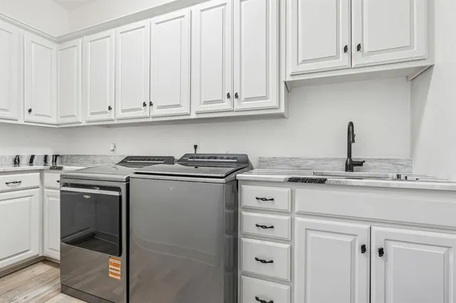 a kitchen with stainless steel appliances granite countertop a sink and dishwasher with white cabinets