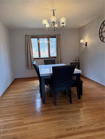 a view of a dining room with furniture a chandelier and wooden floor