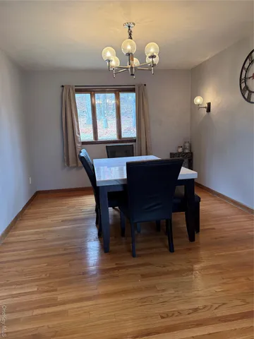 a view of a dining room with furniture a chandelier and wooden floor