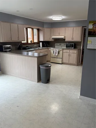 a kitchen with stainless steel appliances kitchen island granite countertop a stove sink and cabinets