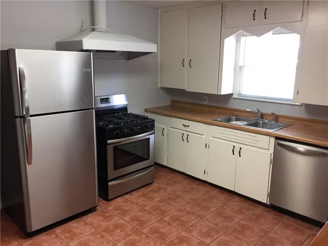 a kitchen with a refrigerator sink and cabinets