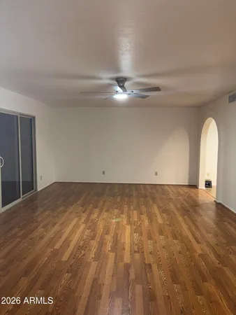 a view of an empty room and chandelier fan