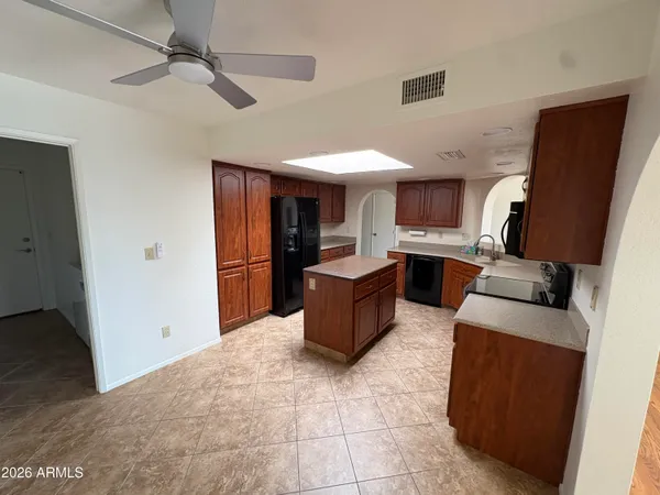 a kitchen with stainless steel appliances granite countertop a refrigerator stove top oven and cabinets