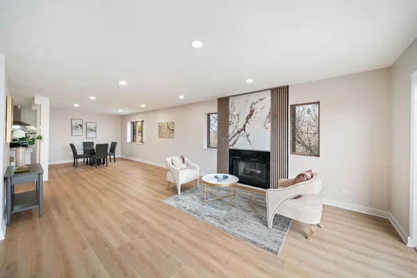 a living room with furniture a fireplace and wooden floor