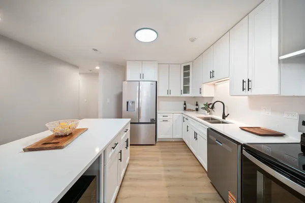 a kitchen with white cabinets and white appliances