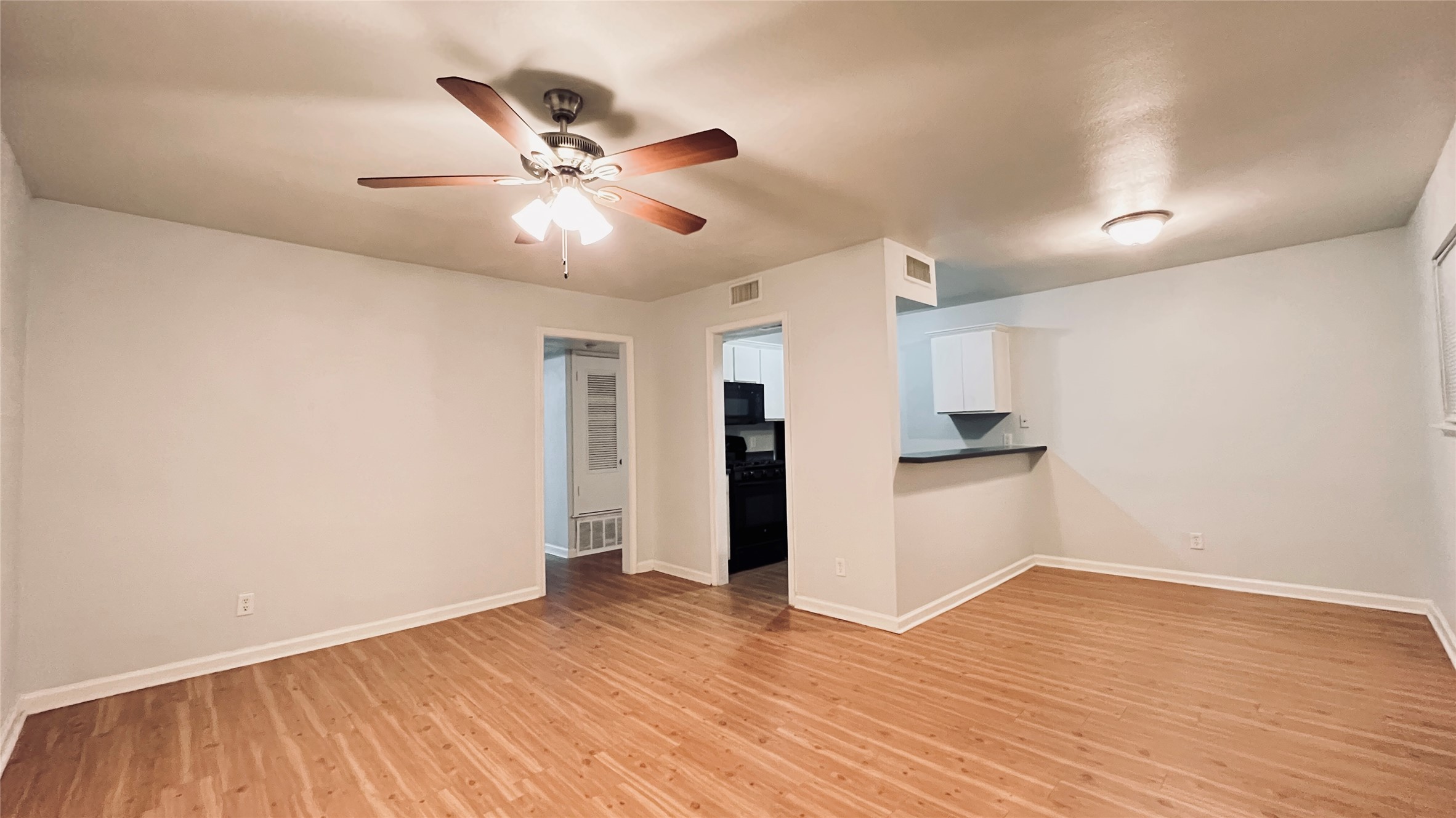 2301 Ohlen Road, Unit 209 Austin, TX 78757 - Photo 1 of 10 A well-lit interior features warm wood flooring and a refreshing ceiling fan.