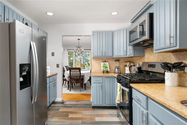 a kitchen with stainless steel appliances granite countertop a refrigerator a stove top oven a sink and dishwasher