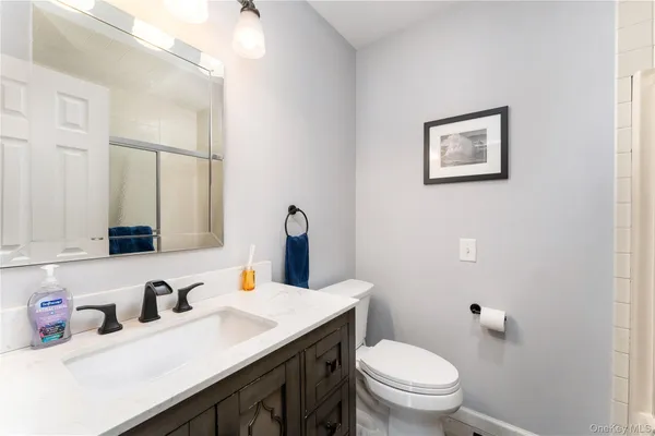 a bathroom with a sink vanity mirror and toilet