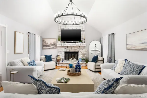 a living room with furniture a flat screen tv and a fireplace