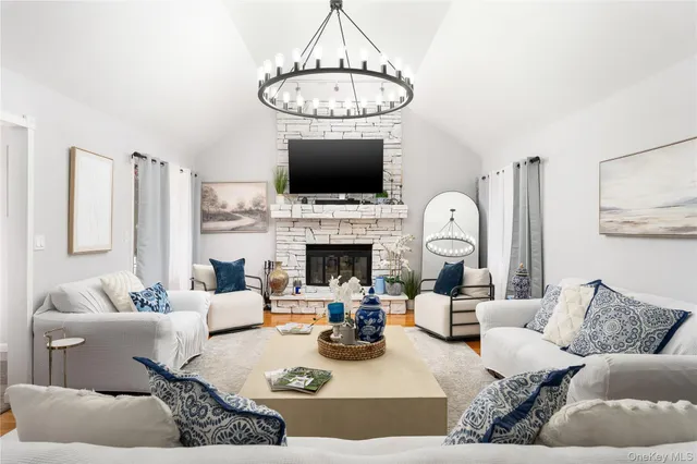 a living room with furniture a flat screen tv and a fireplace