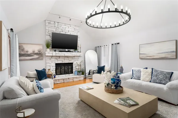 a living room with furniture a flat screen tv and a fireplace