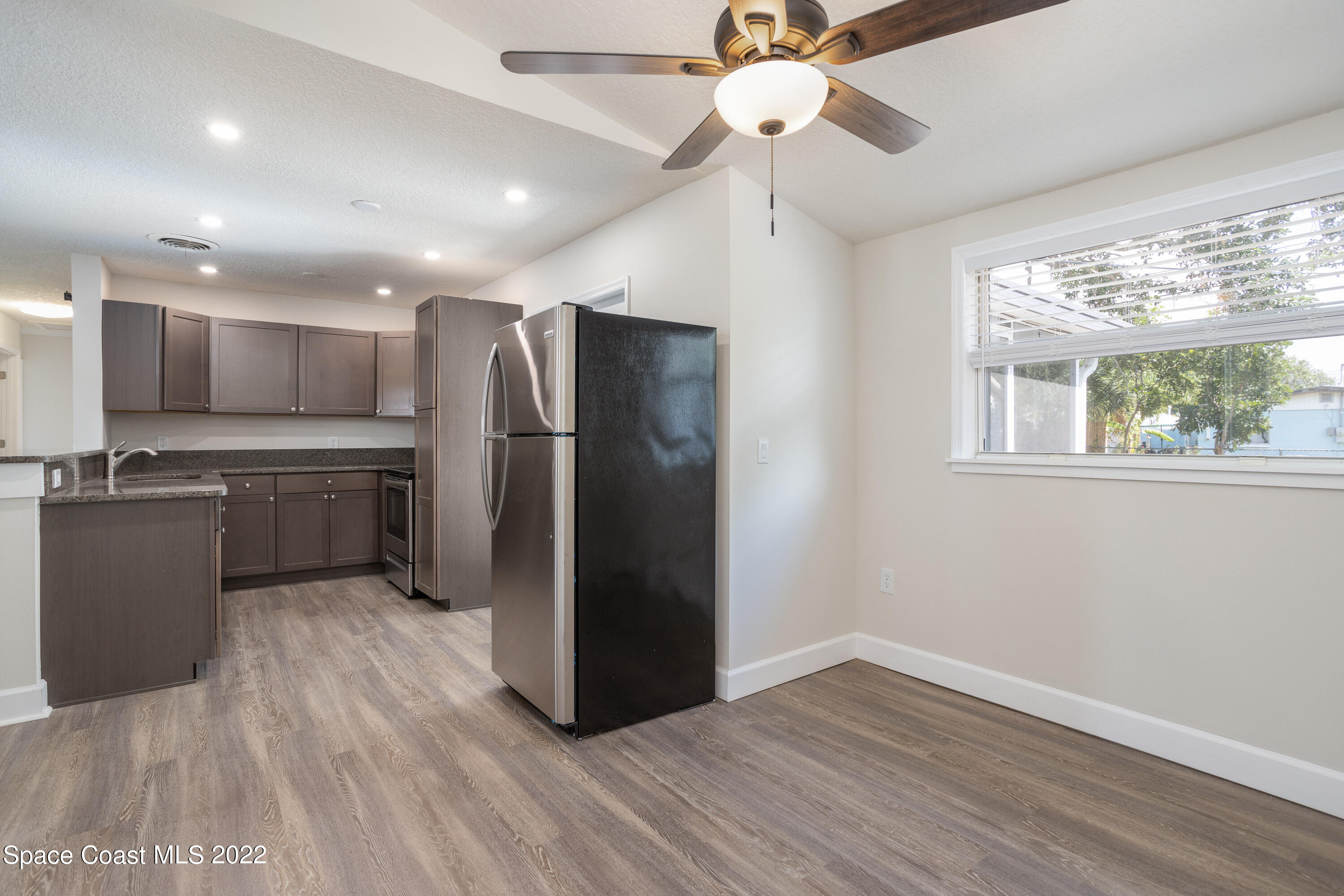 2602 Post Road Melbourne, FL 32935 - Photo 7 of 22 a kitchen with kitchen island a counter top space wooden floor and stainless steel appliances