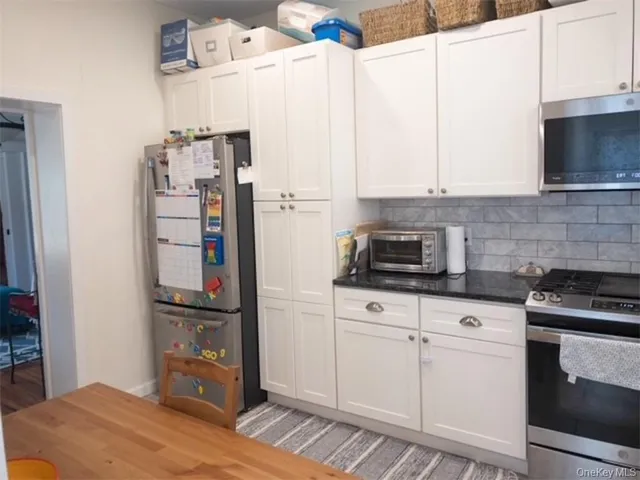 a kitchen with stainless steel appliances granite countertop a refrigerator sink and stove