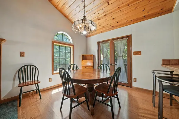 a view of a dining room with furniture a chandelier and wooden floor