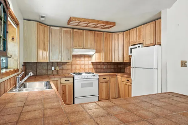 a kitchen with stainless steel appliances granite countertop a refrigerator sink and stove