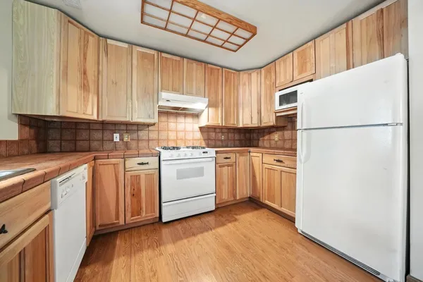 a kitchen with white cabinets and white appliances