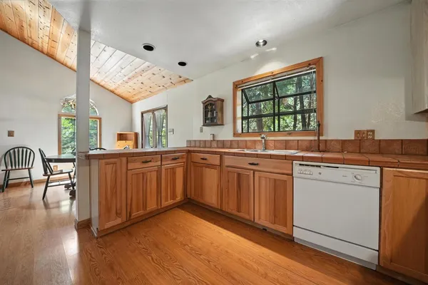 a kitchen with stainless steel appliances granite countertop wooden floors and sink