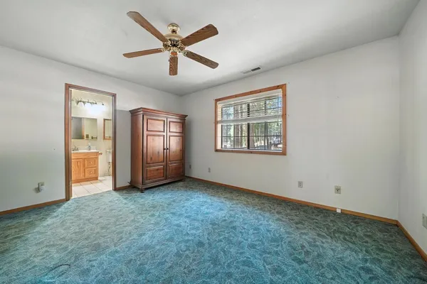 a view of an empty room with window and closet area