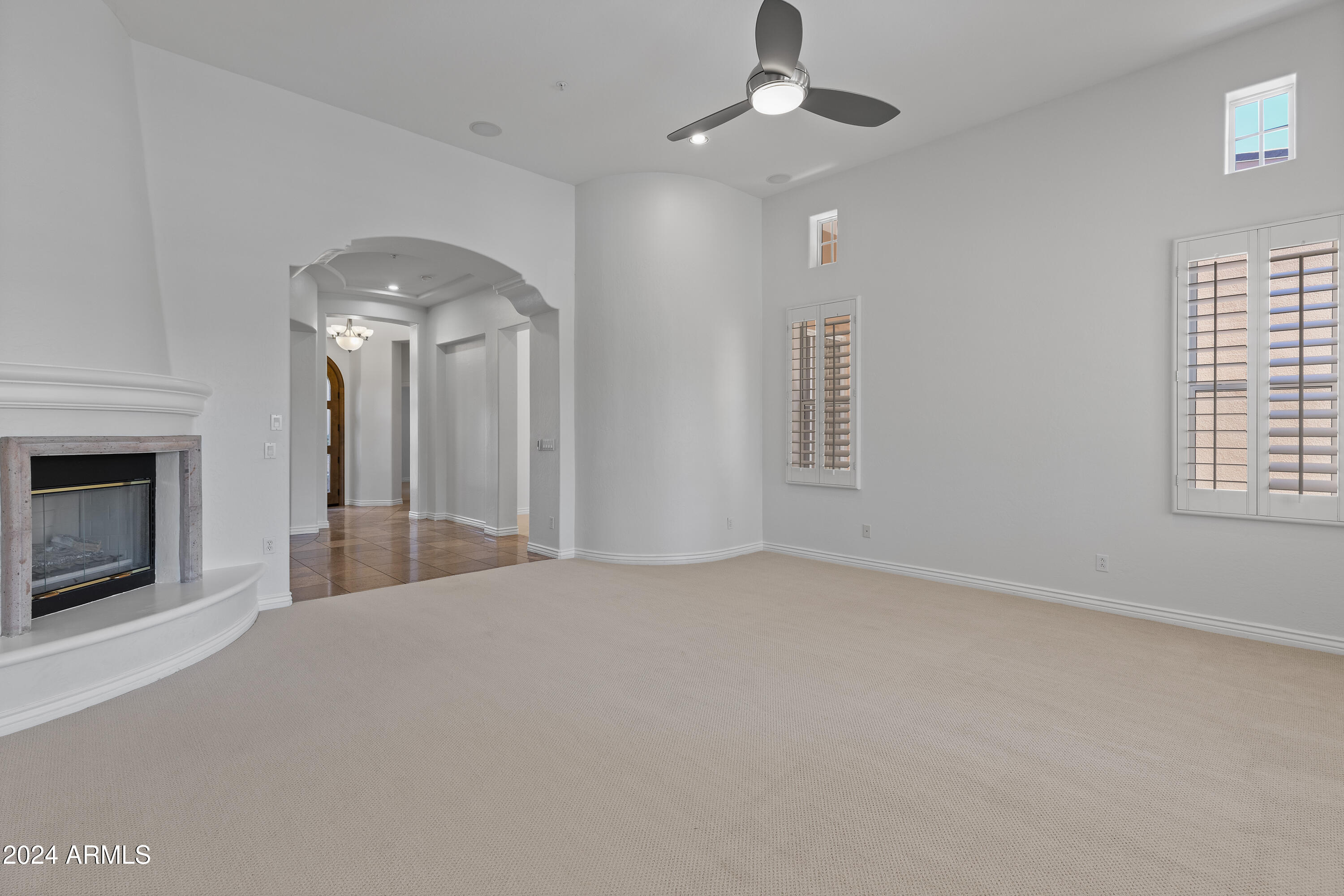 8883 East Mountain Spring Road Scottsdale, AZ 85255 - Photo 10 of 48 an empty room with chandelier fan and windows