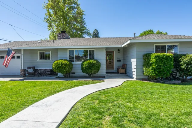 a view of a house with a yard and potted plants