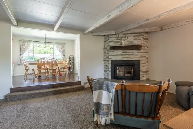 a dining room with furniture a fireplace and wooden floor