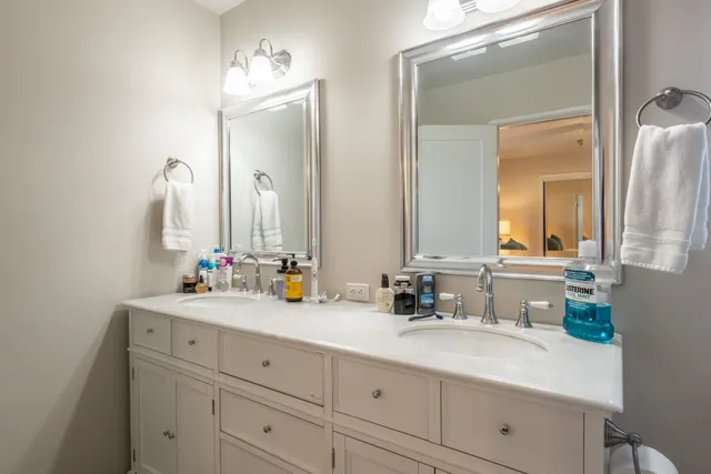 a bathroom with double vanity sinks and a mirror