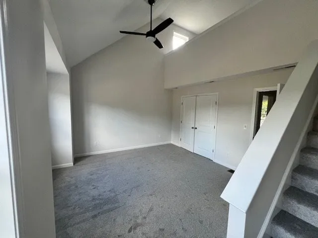 an empty room with windows and ceiling fan view